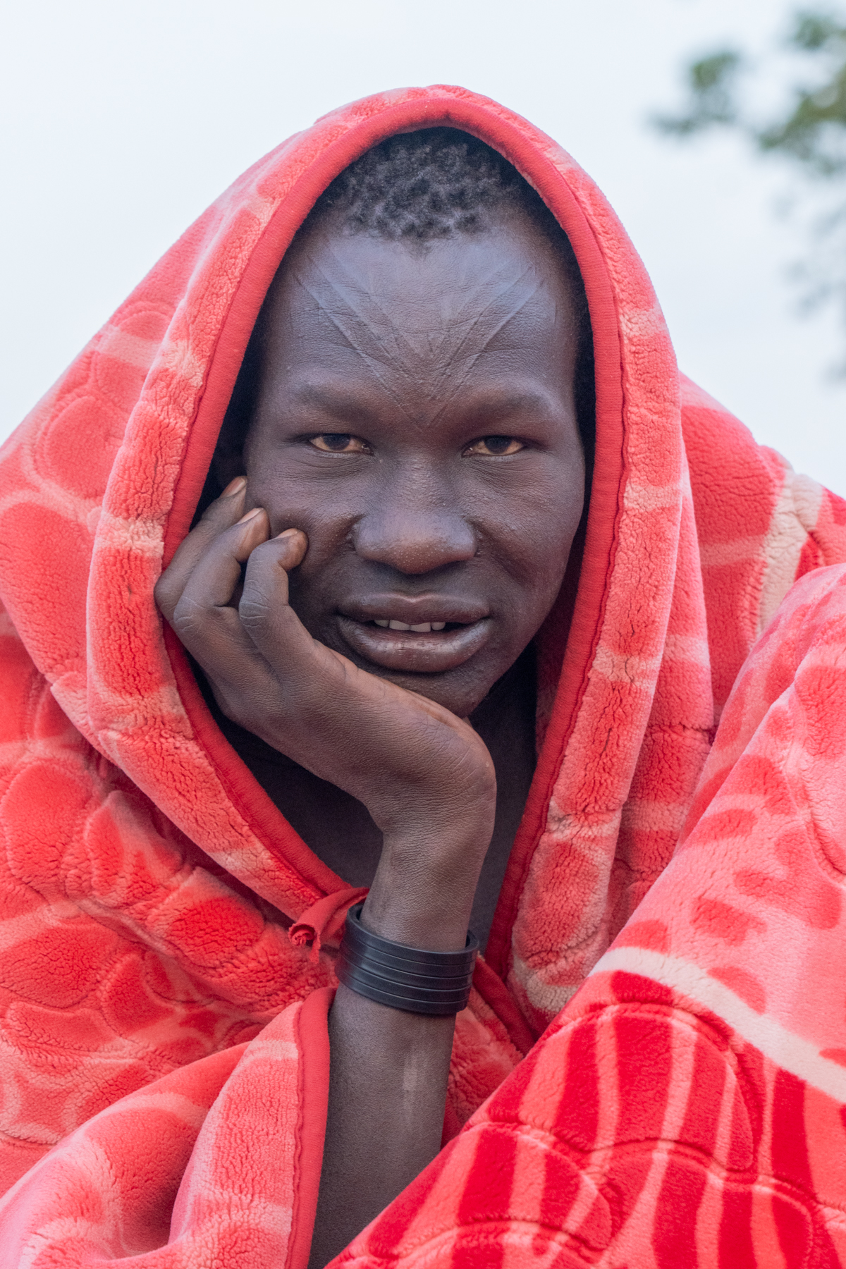 Early morning Mundari man draped in a blanket to stay warm (image by Inger Vandyke)
