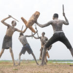 Mundari men practicing fighting using traditional guards, shields and clubs (image by Inger Vandyke)