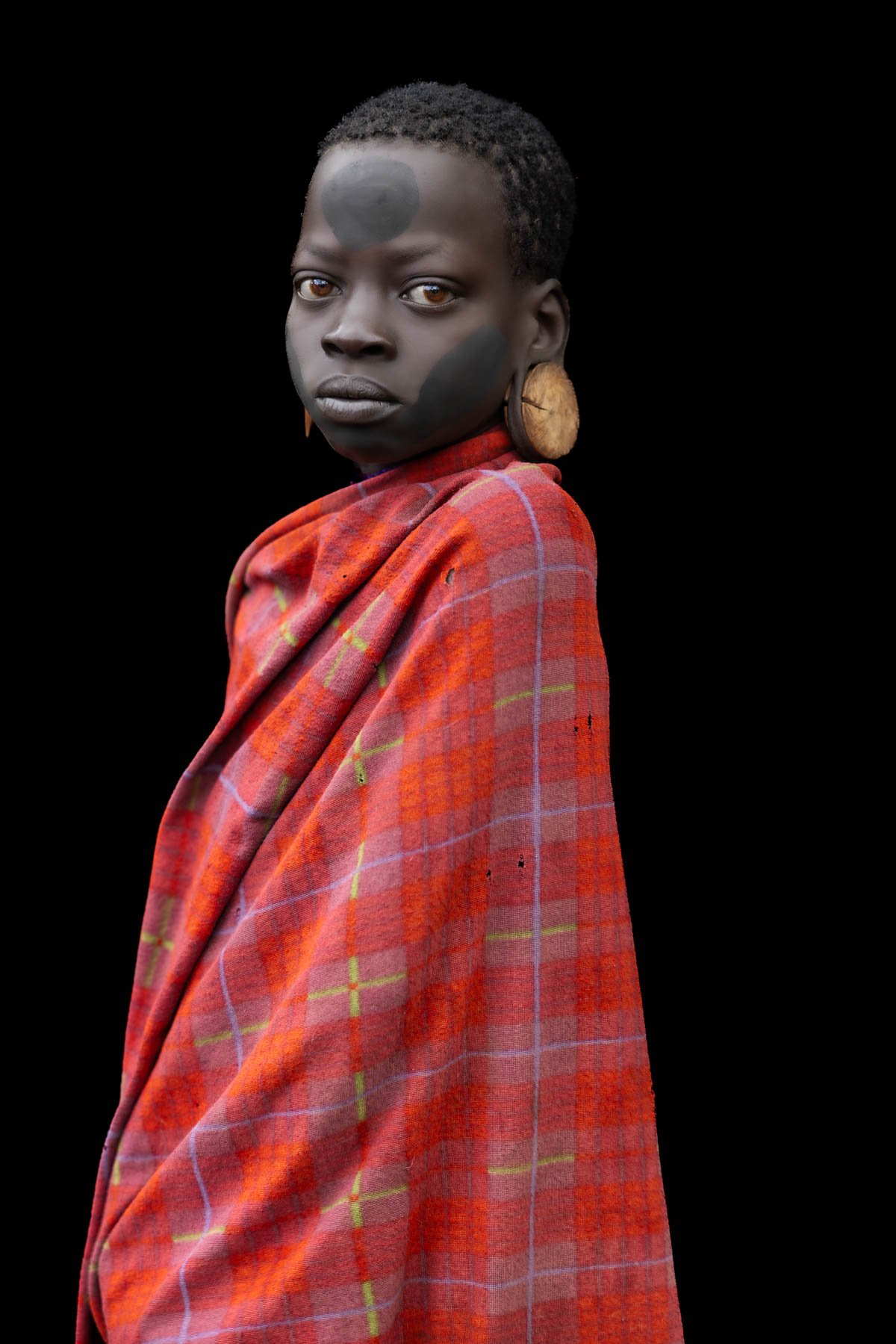 Mursi girl, wrapped in a traditional cloth, her face marked with natural pigments. (image by Ingrid Koedood)