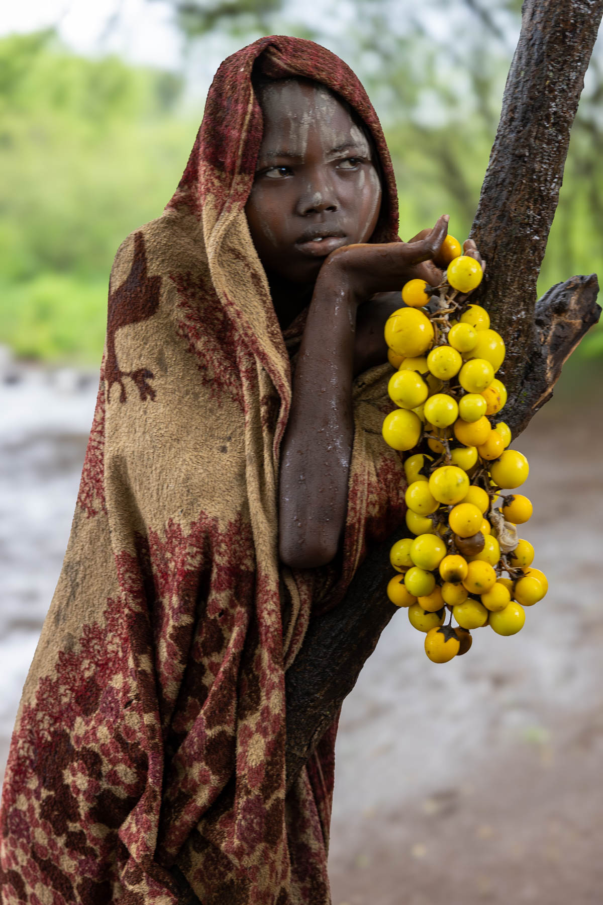 A Mursi girl watching from a distance as we photograph, while the rain slowly sets in. (image by Ingrid Koedood)