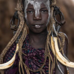Warm colors, strong presence, a young Mursi girl wrapped in textures of tradition. (image by Ingrid Koedood)