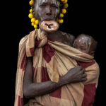 A portrait of a Mursi woman with lip plate holding her baby. (image by Ingrid Koedood)