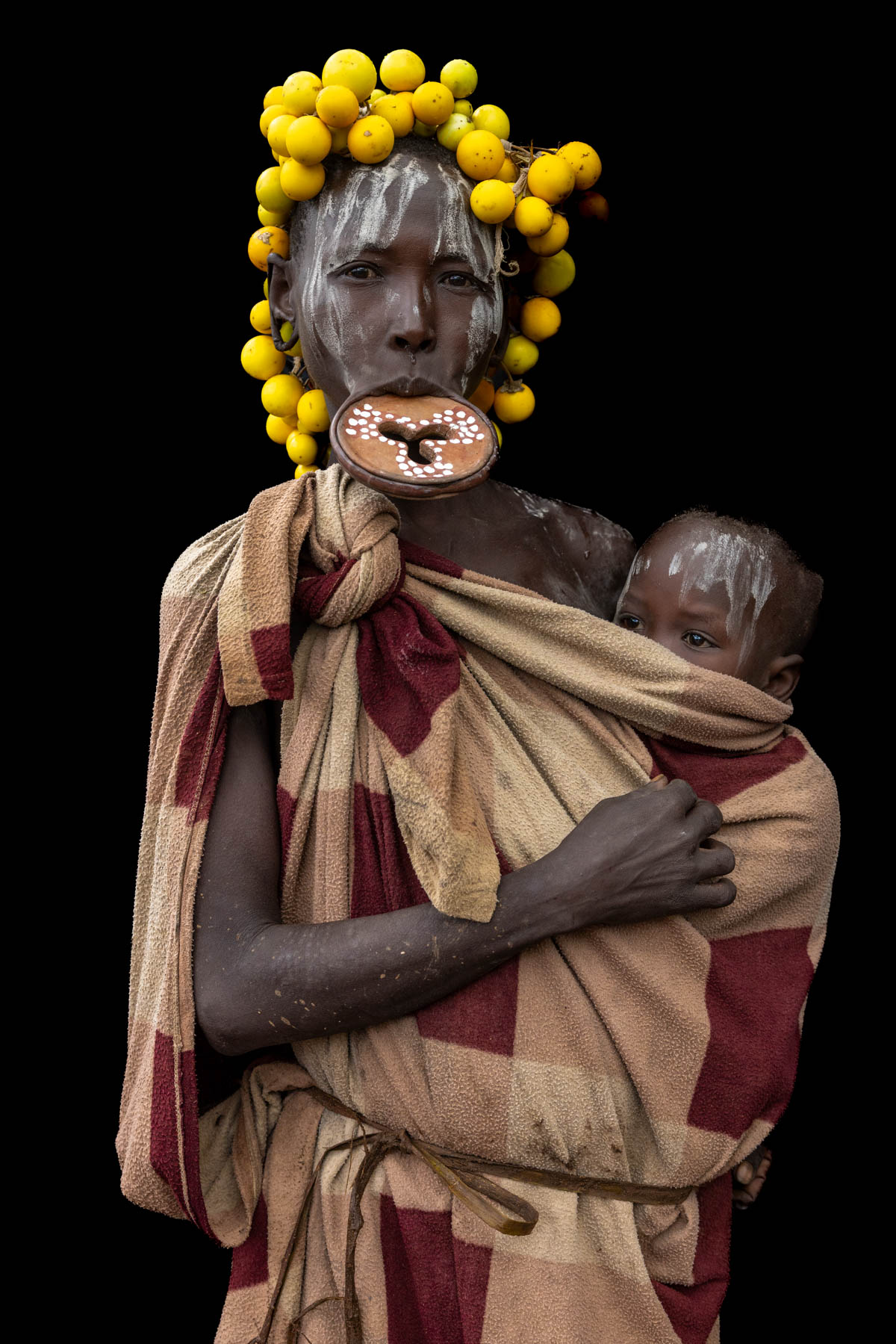 A portrait of a Mursi woman with lip plate holding her baby. (image by Ingrid Koedood)