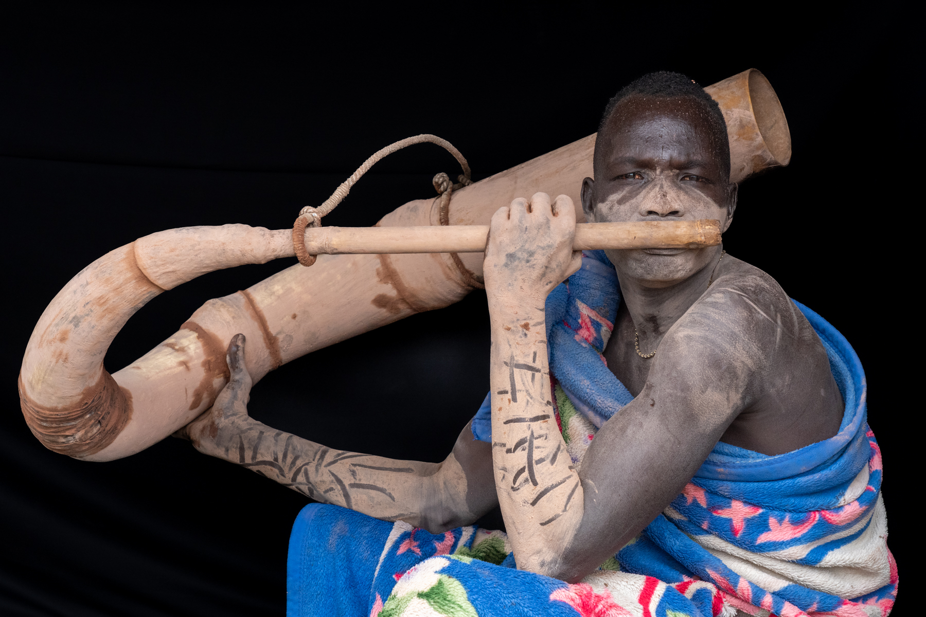 Portrait of a Mundari man playing Tung (image by Inger Vandyke)