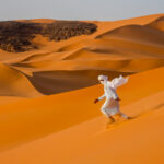 Flying Tuareg. There's no better way to descend the dunes of Moulenaga than running! (image by Inger Vandyke)