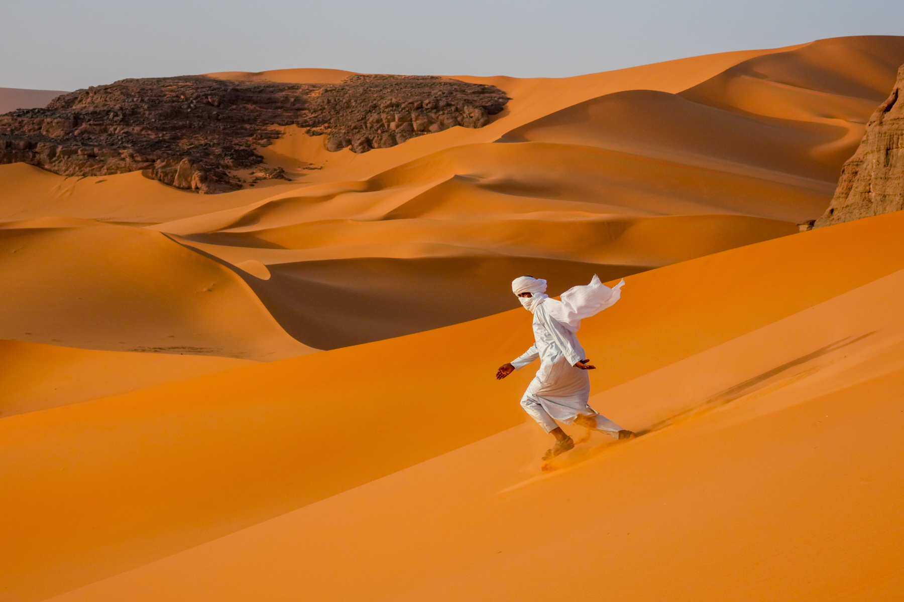 Flying Tuareg. There's no better way to descend the dunes of Moulenaga than running! (image by Inger Vandyke)