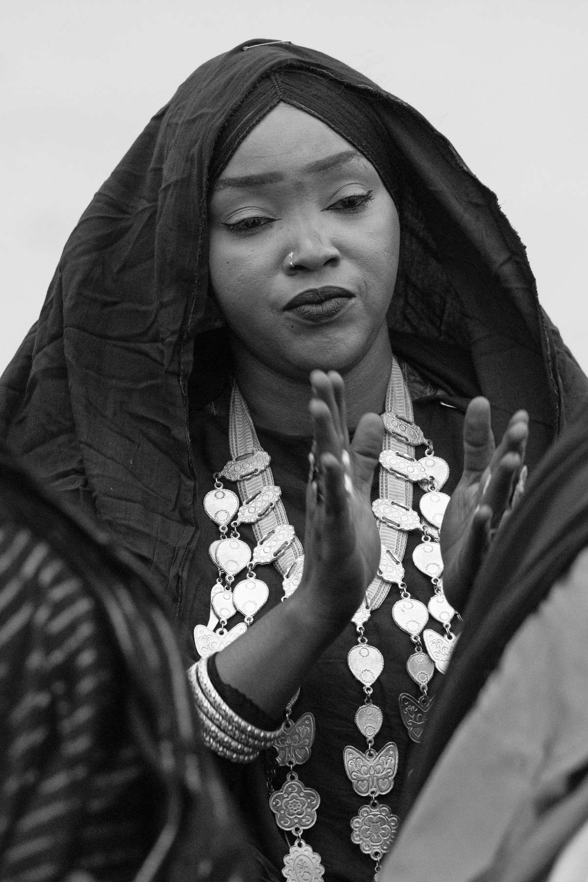 A Tuareg woman clapping her hands at a ceremony of Tahamat in the desert (image by Inger Vandyke)