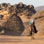 Tuareg men riding camels in the desert (image by Inger Vandyke)