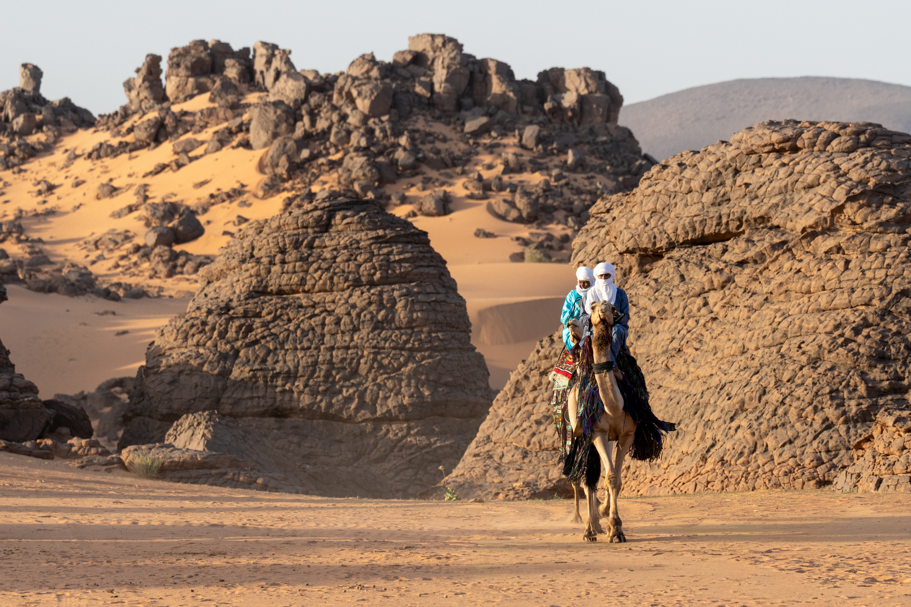 Tuareg men riding camels in the desert (image by Inger Vandyke)