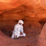 Our guide, Youssef, giving scale to the base cave in a rock pillar (image by Inger Vandyke)