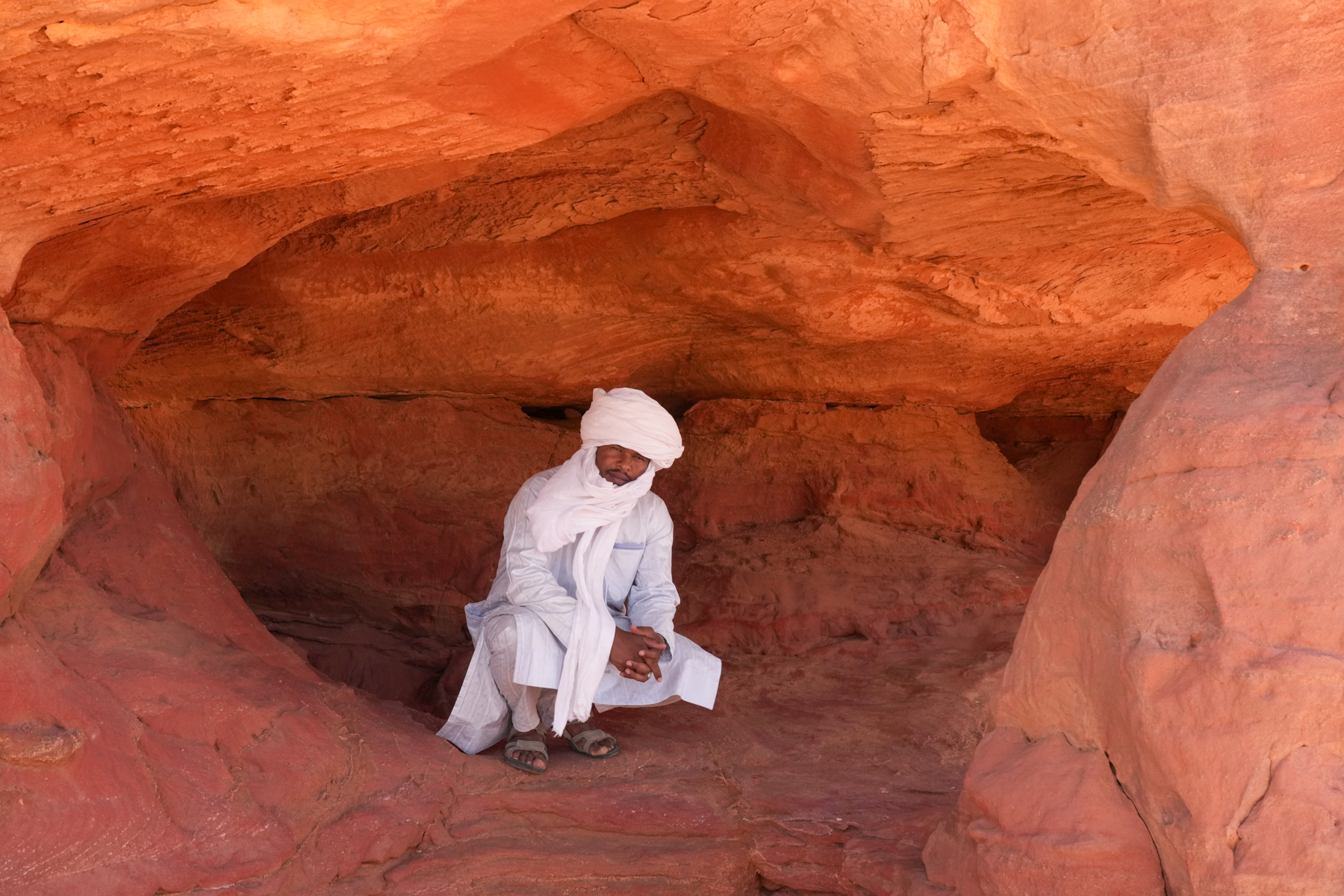 Our guide, Youssef, giving scale to the base cave in a rock pillar (image by Inger Vandyke)