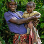 Echuya Twa mum Mugabirwe hugs her infant daughter while wearing traditional forest headwear. The Echuya Twa (or Batwa) are a distinct - but heavily marginalised - indigenous community living on the edges of the Echuya Forest Reserve in the Kisoro and Kabale districts of southwestern Uganda (image by Virginia Wilde)