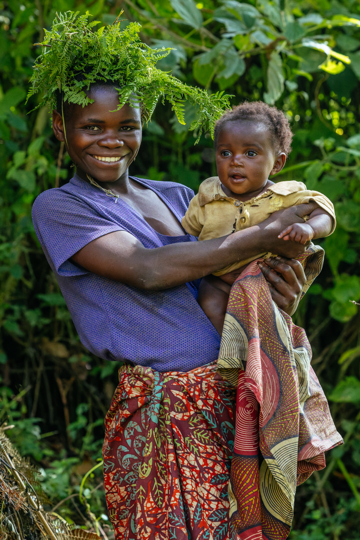 Echuya Twa mum Mugabirwe hugs her infant daughter while wearing traditional forest headwear. The Echuya Twa (or Batwa) are a distinct - but heavily marginalised - indigenous community living on the edges of the Echuya Forest Reserve in the Kisoro and Kabale districts of southwestern Uganda (image by Virginia Wilde)