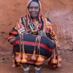 An elderly Borana woman with her decorative calabashes and traditional leather decorations (image by Inger Vandyke)