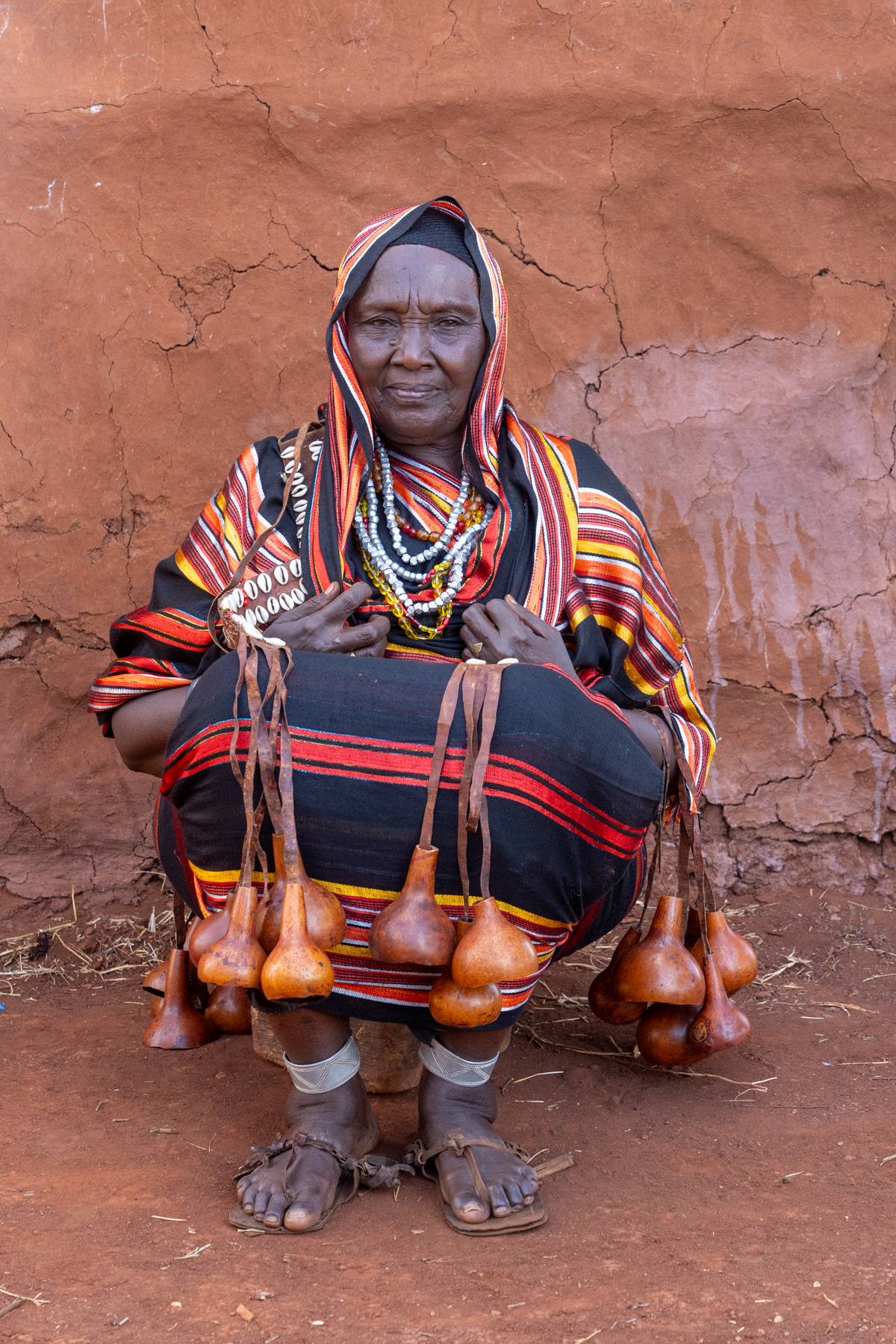 An elderly Borana woman with her decorative calabashes and traditional leather decorations (image by Inger Vandyke)