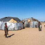 Children play around the large homes of Dassanech people in remote Kenya (image by Inger Vandyke)