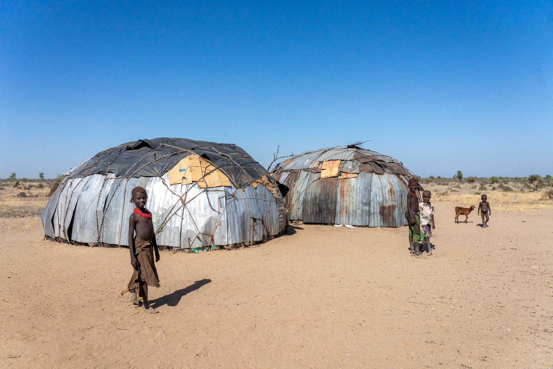 Children play around the large homes of Dassanech people in remote Kenya (image by Inger Vandyke)