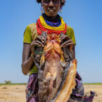 A Dassanech woman carrying a dried mudfish - lunch! (image by Inger Vandyke)