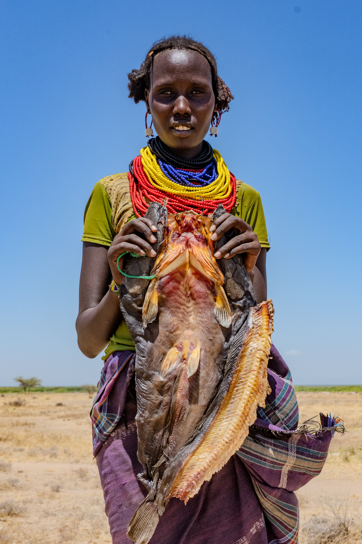 A Dassanech woman carrying a dried mudfish - lunch! (image by Inger Vandyke)