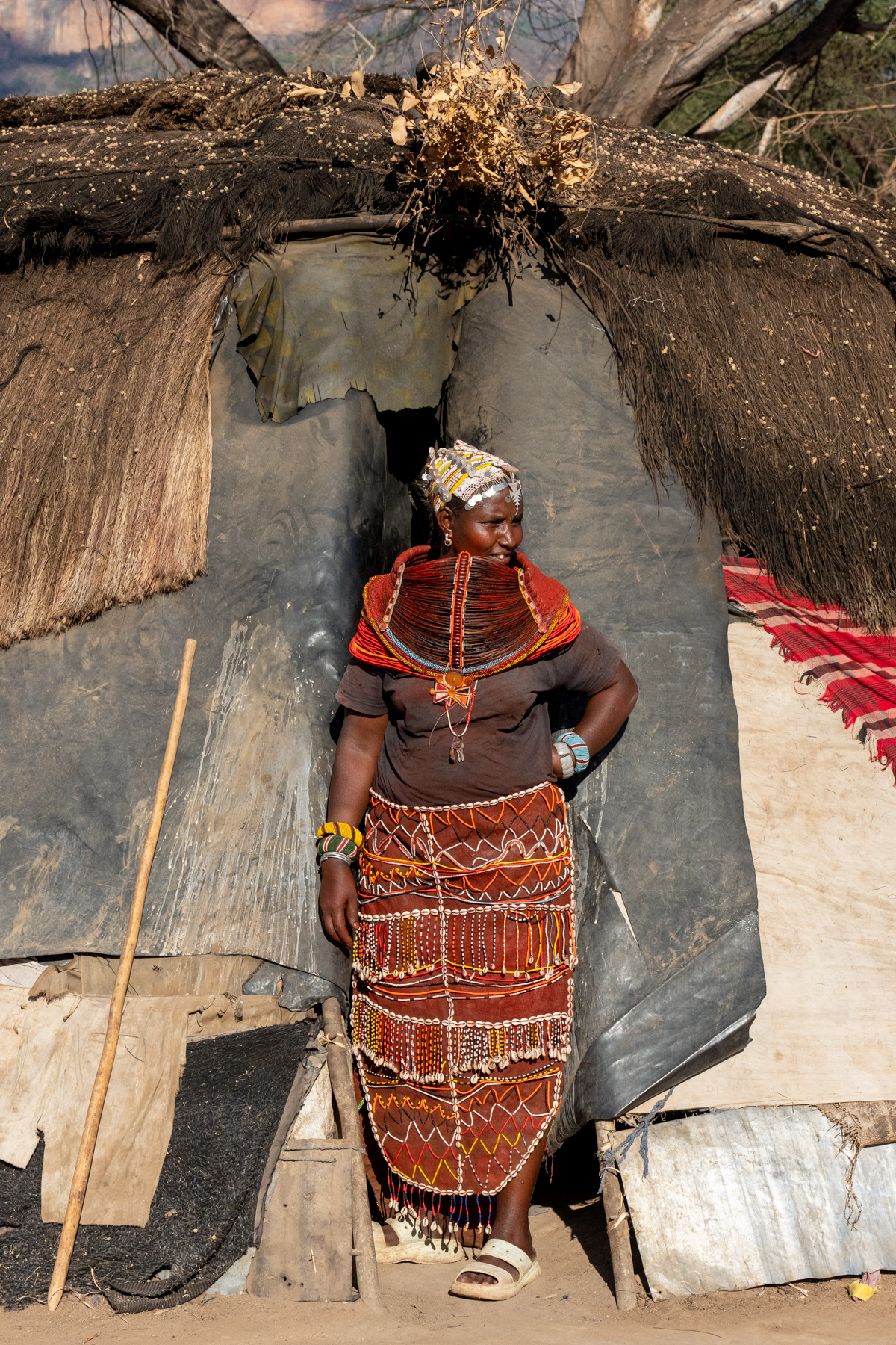 A Rendille woman wearing her Mbaro necklace at the entrance of a local spirit house (image by Inger Vandyke)