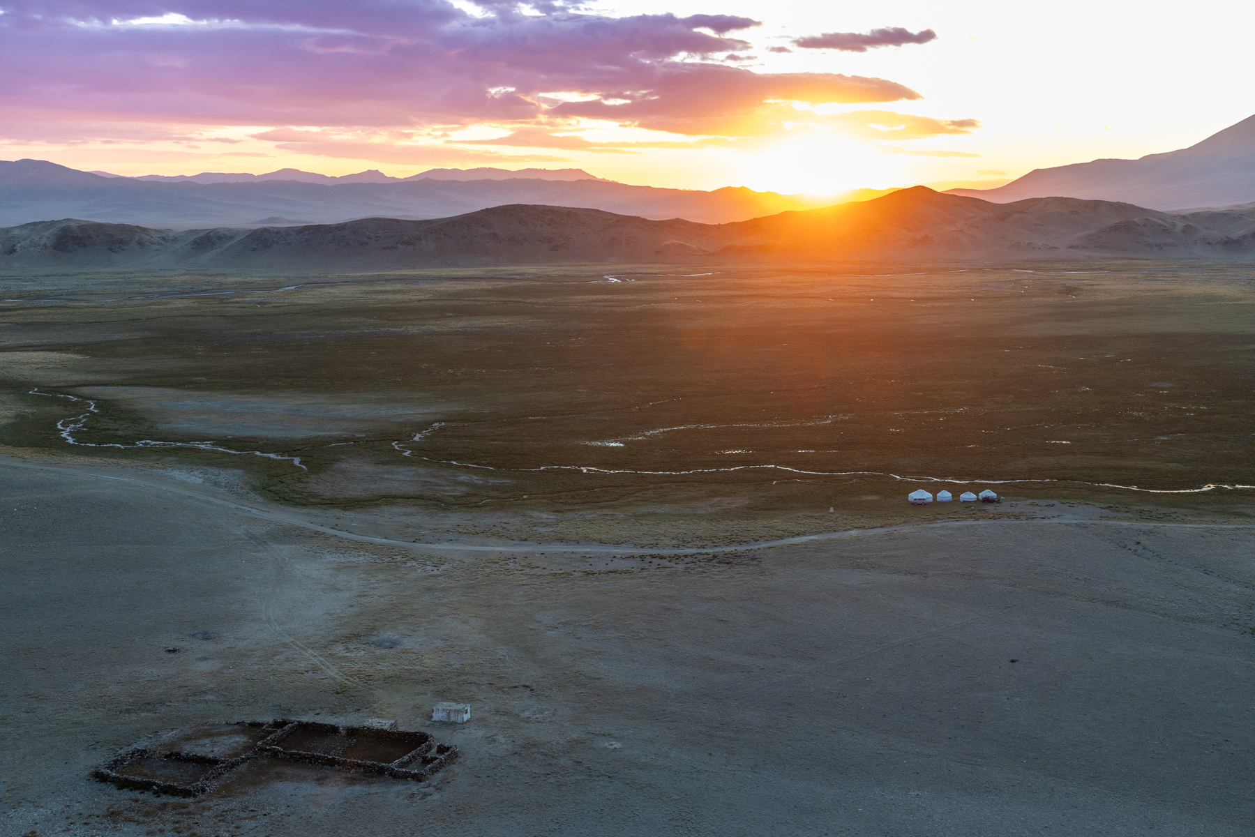 Sunrise over the mountains of western Mongolia, with a traditional winter residence in the foreground and the yurts of our first eagle-hunter family visible in the distance (image by Ingrid Koedood)