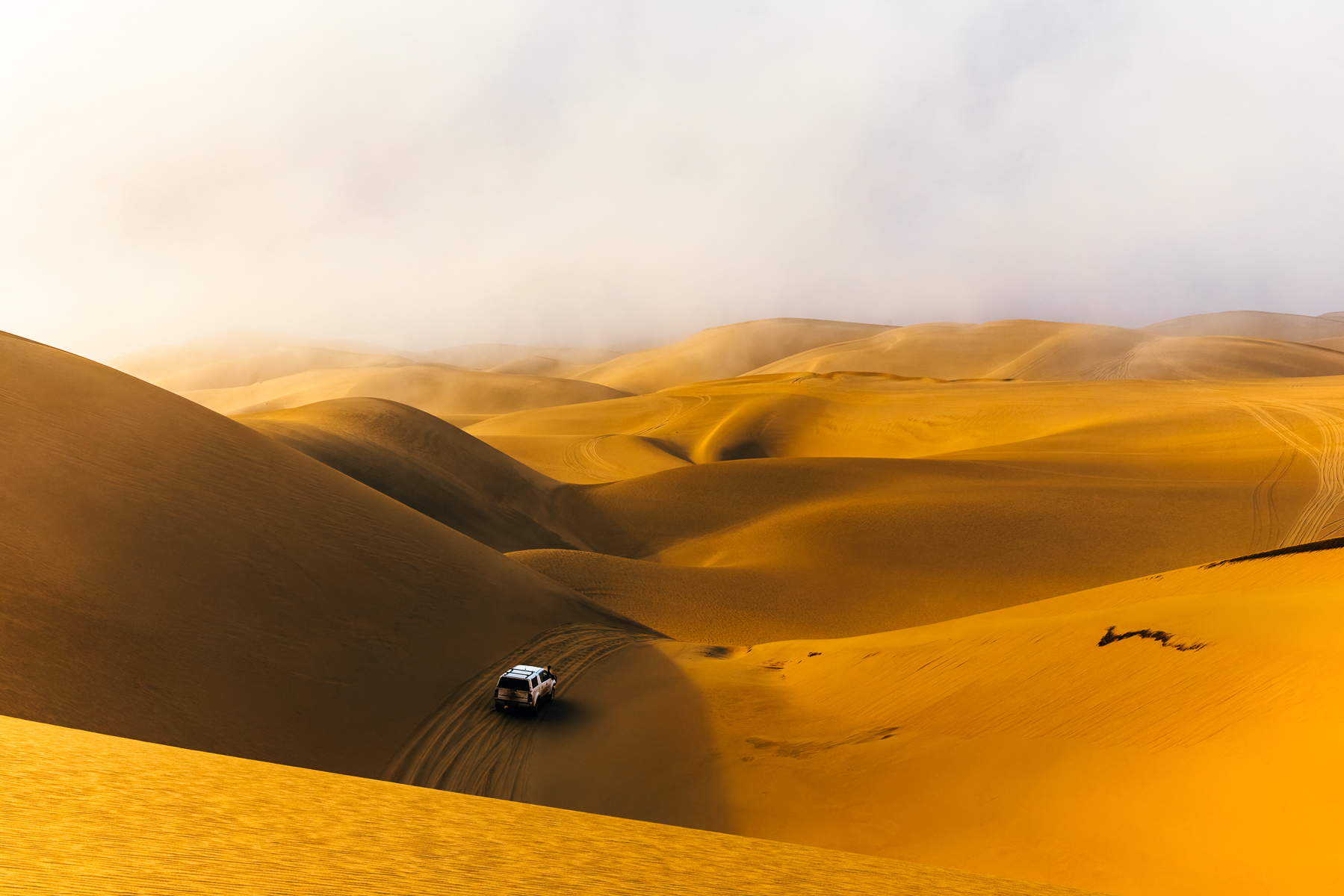 One of our 4x4 vehicles sweeps over dunes during an adventure drive day to Namibia's Sandwich Harbour, part of the Namib-Naukluft National Park. Some of the dunes rise to more than 100 metres in places, before running directly down towards the Atlantic Ocean (image by Virginia Wilde)