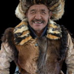 Portrait of an eagle hunter in our lunch tent during the Eagle Festival, showing off his biggest smile for the camera (image by Ingrid Koedood)