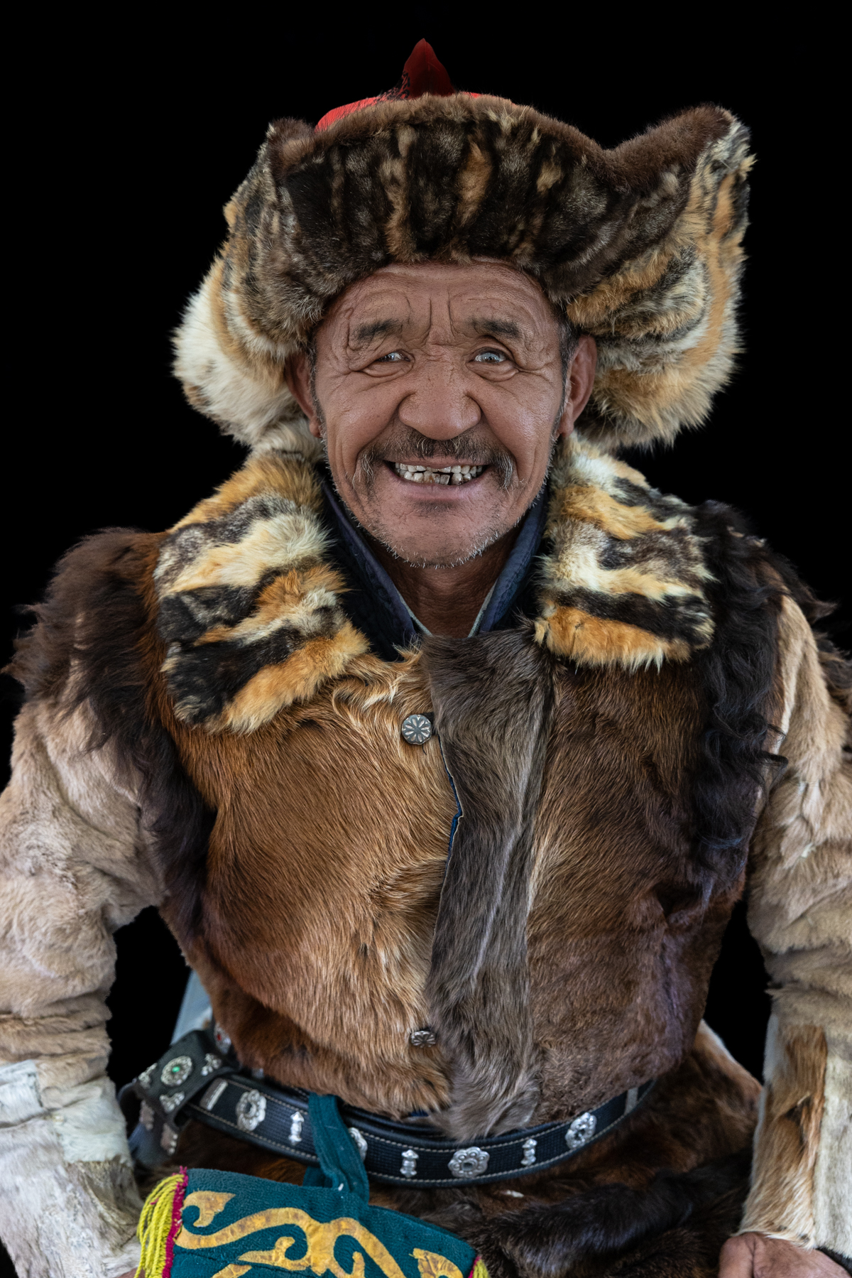Portrait of an eagle hunter in our lunch tent during the Eagle Festival, showing off his biggest smile for the camera (image by Ingrid Koedood)