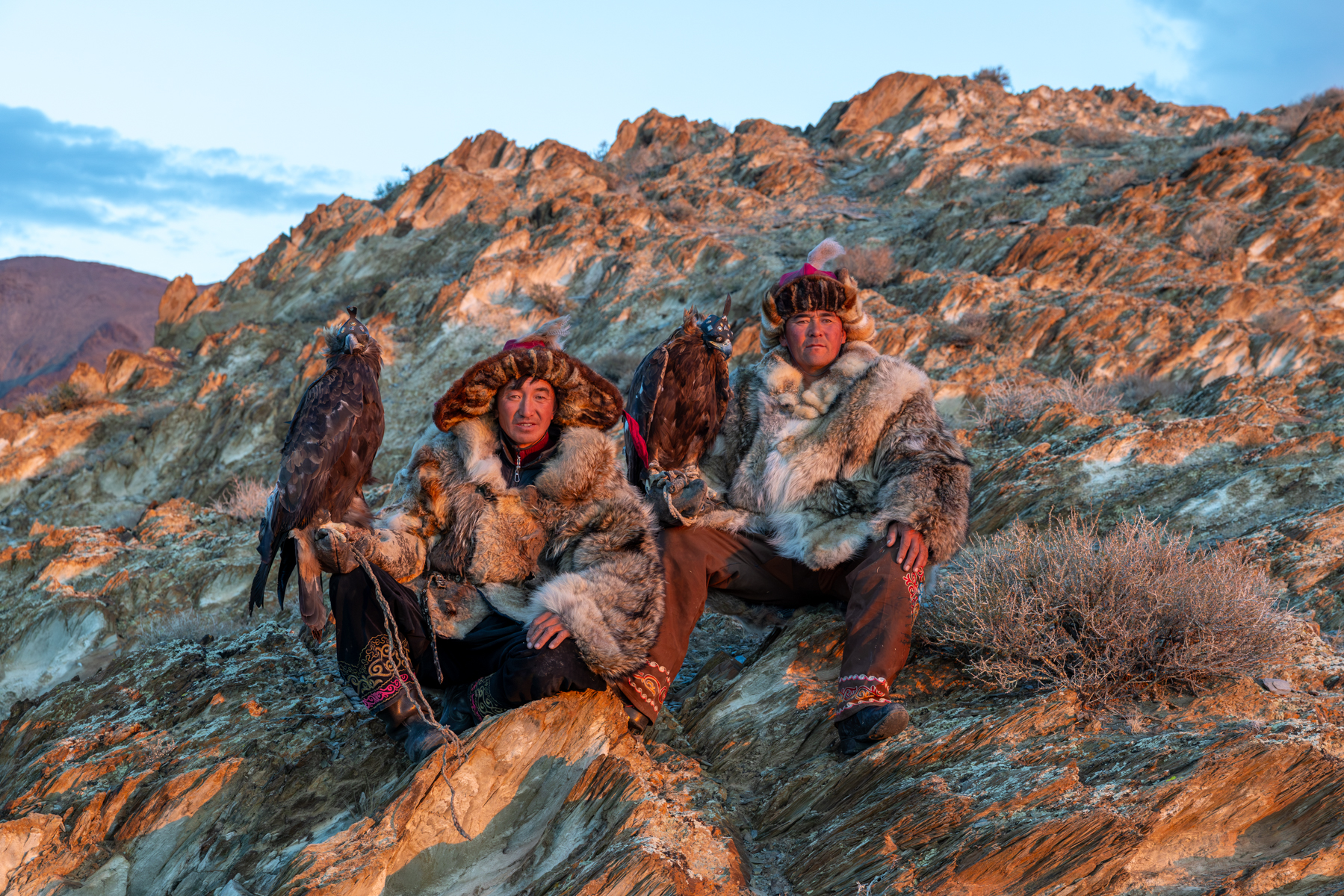 Two Kazakh eagle hunters with their golden eagles at sunrise, during our stay with their family (image by Ingrid Koedood)
