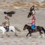 In full motion, eagle hunters gallop across the landscape with their eagles (image by Ingrid Koedood)