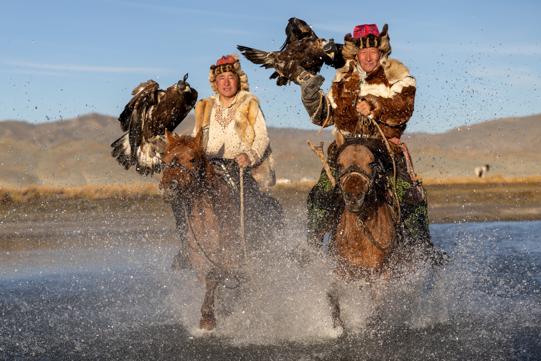 Bashakan and his son, Serekjan, ride through the water with their golden eagles (image by Ingrid Koedood)