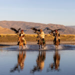 Early in the morning, just after sunrise, the eagle hunters gallop through the water with their golden eagles (image by Ingrid Koedood)