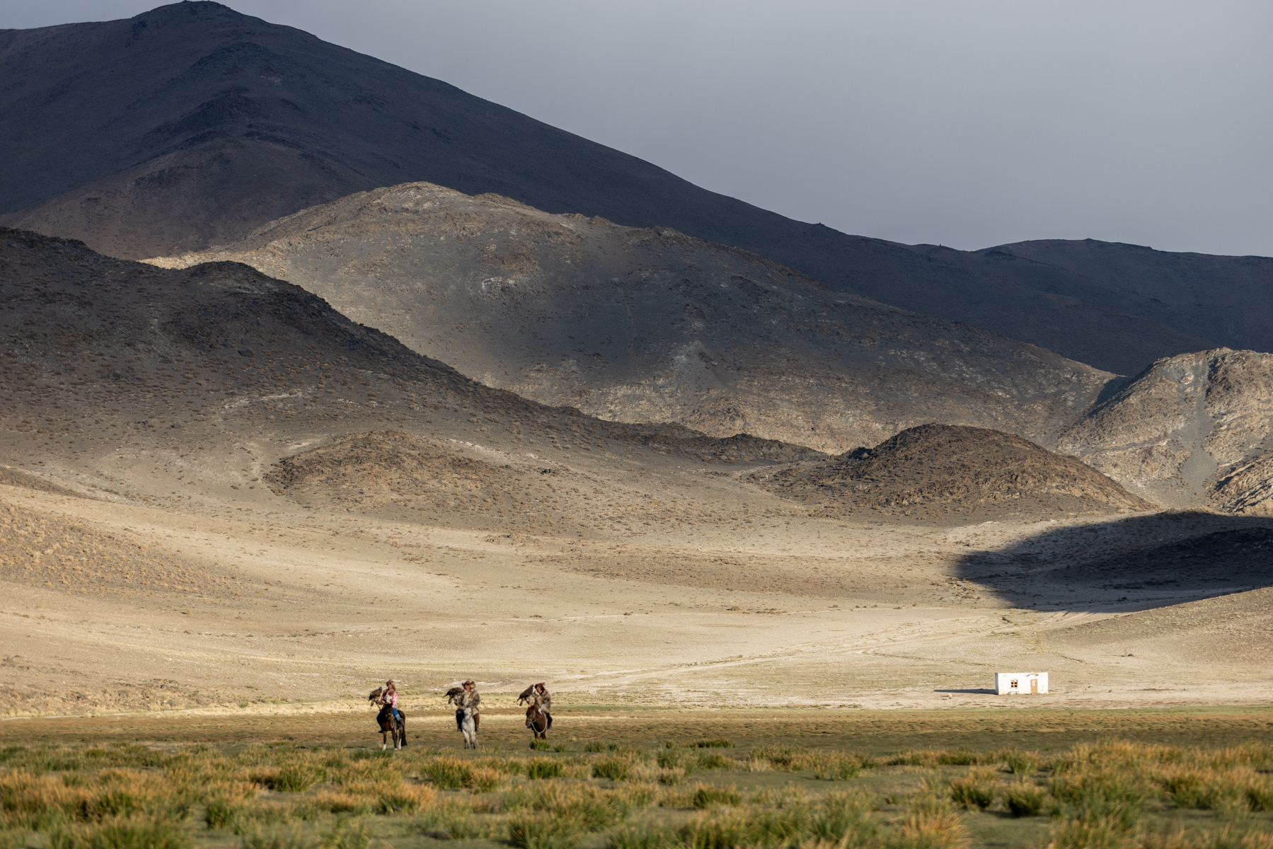 Three eagle hunters make their way across the vast mountain landscape of western Mongolia (image by Ingrid Koedood)