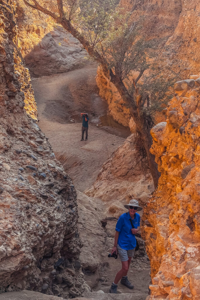 Namibia tour-member Ruth smiles at the mouth of Sesriem Canyon - a surprisingly fascinating excursion into a gorge by Sossusvlei's Tsauchab River (image by Virginia Wilde)