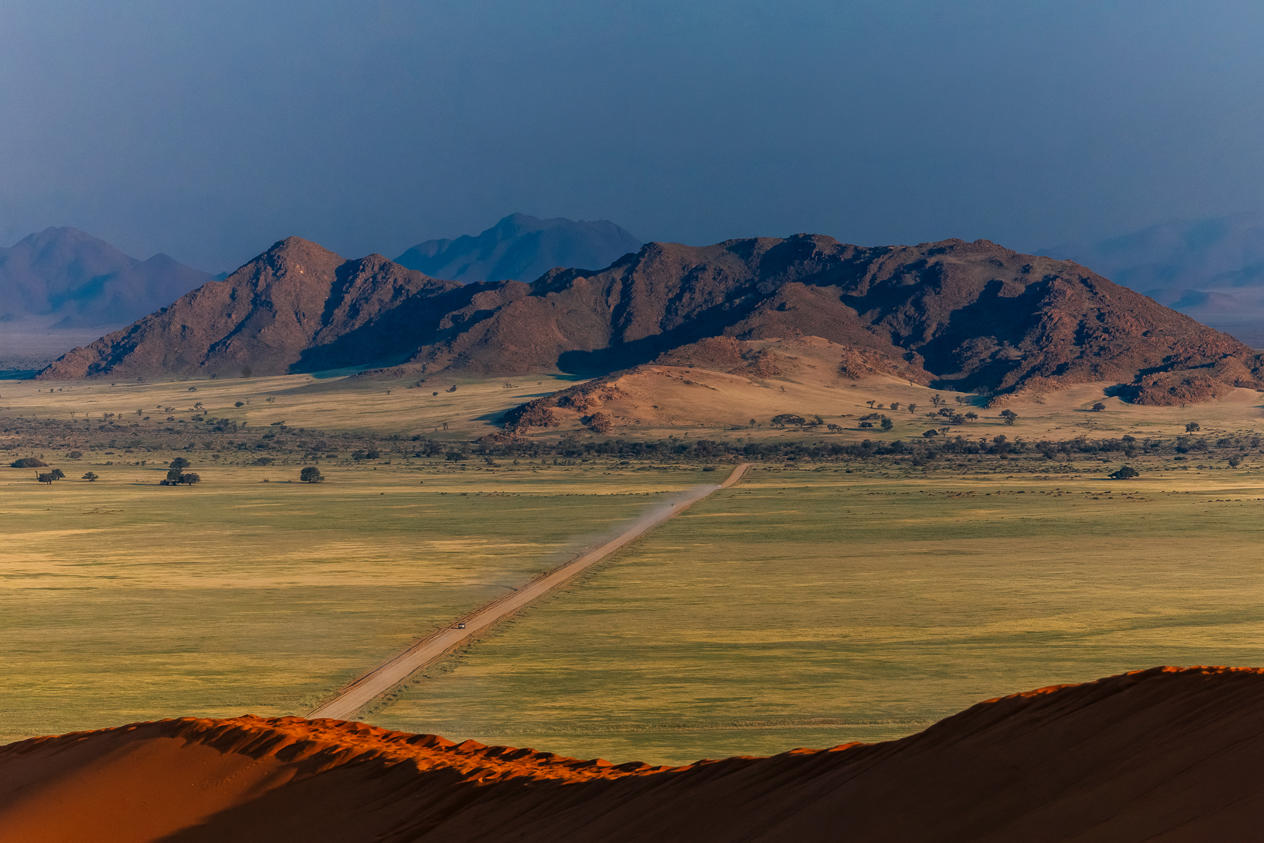 The view from Sossusvlei's 'Elim Dune', with the broad Tsauchab Valley and the mountains behind. The mountains mark the distant source of the ephemeral Tsauchab, which eventually disappears into the sands at Sossusvlei (image by Virginia Wilde)